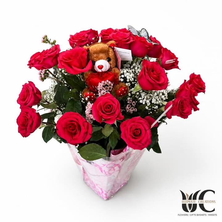 Pink and red rose bouquet with a brown teddy bear and white filler flowers in pink wrapping