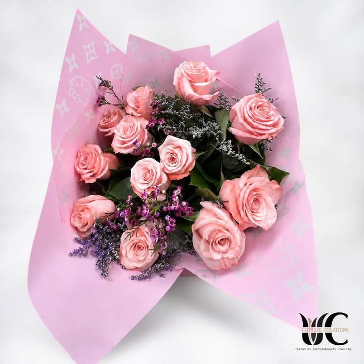 Pink rose bouquet with purple filler flowers and patterned pink wrapping