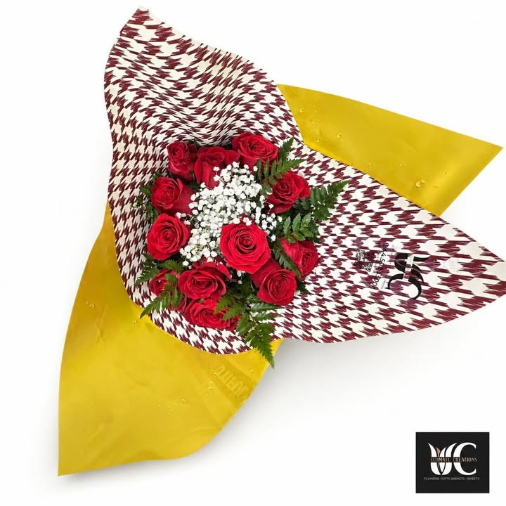 Wrapped bouquet of red roses with white filler flowers and greenery