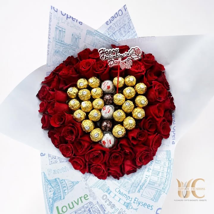 Round bouquet of red roses and wrapped chocolates in illustrated white-and-blue paper.