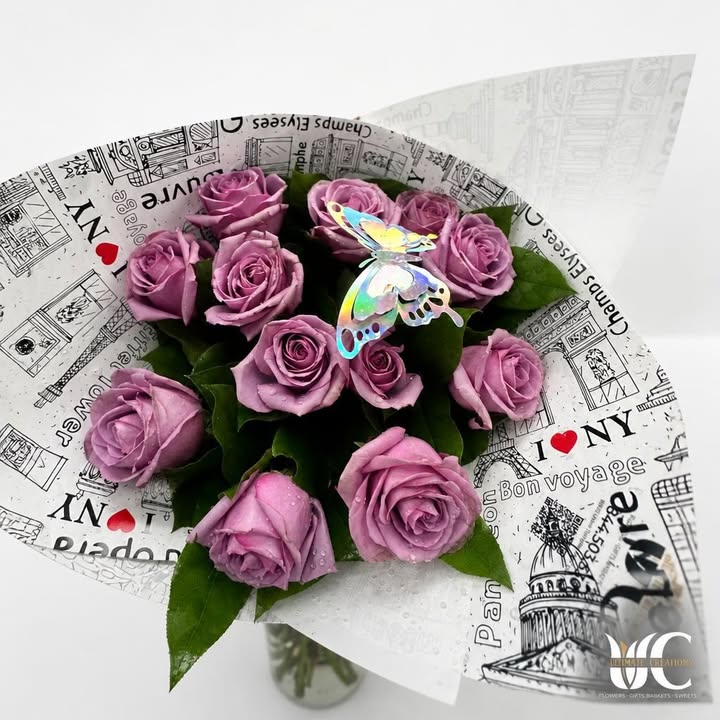 Lavender-pink rose bouquet with greenery, butterfly accent, and black-and-white wrapping