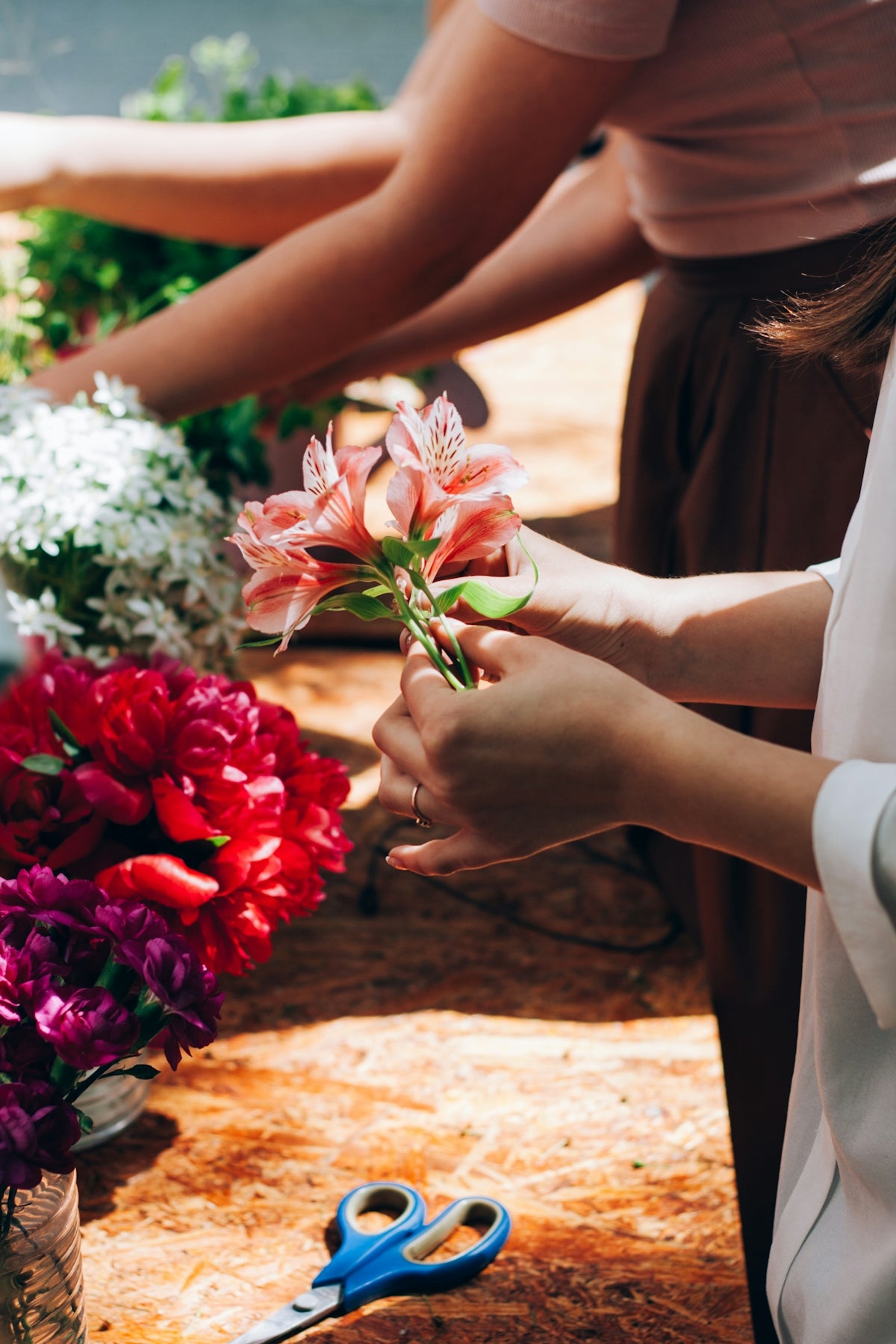 a woman is cutting flowers with scissors