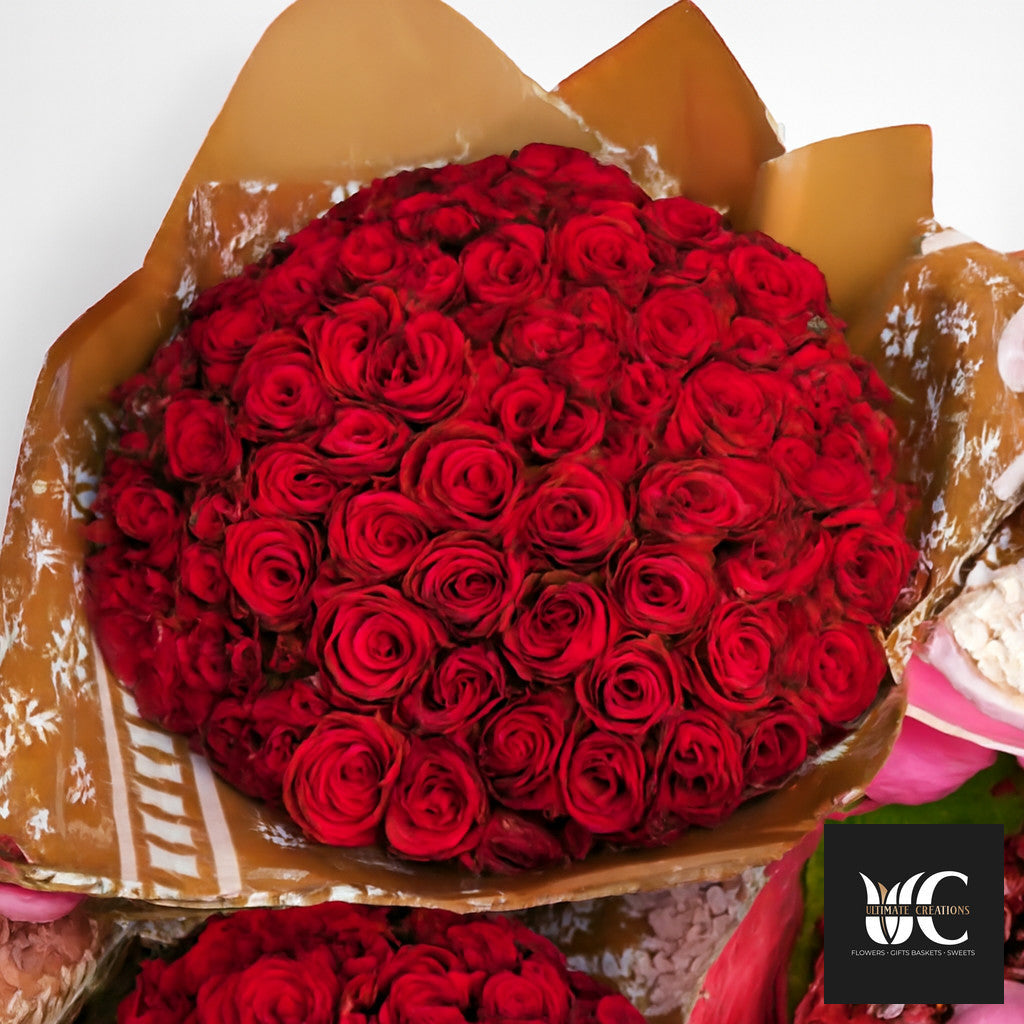 Large bouquet of red roses wrapped in brown and cream paper.