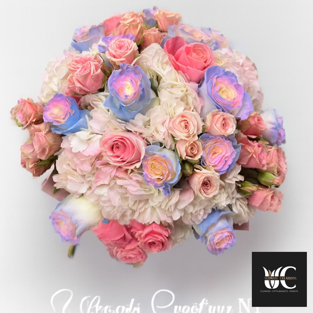 Large pastel bouquet with pink and white roses and soft blue and lavender-tinted blooms arranged in a rounded design.