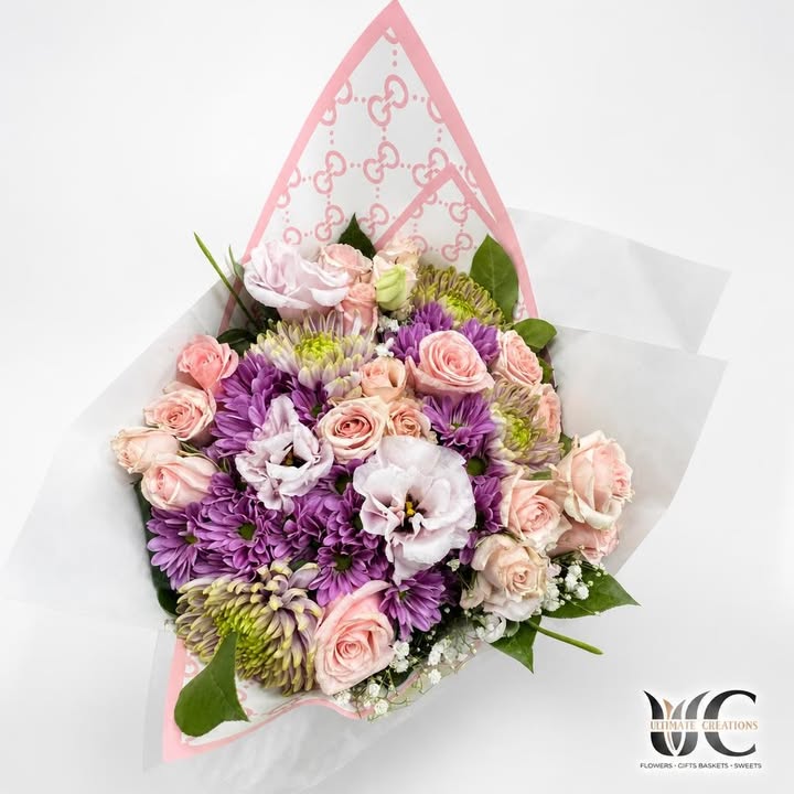 Pastel pink and lavender bouquet with layered wrapping and greenery