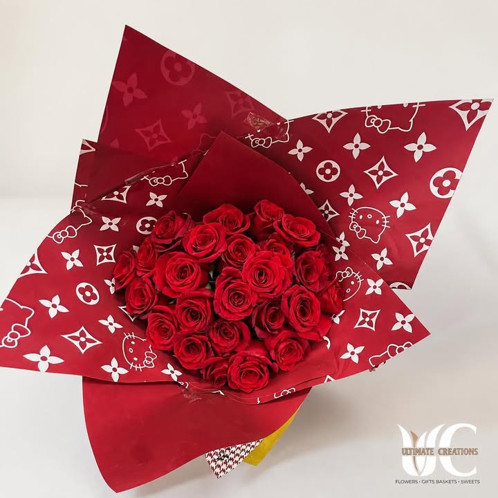 Rounded bouquet of red roses in patterned red-and-white wrapping