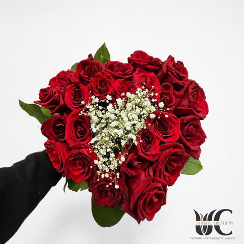 Rounded bouquet of red roses with white baby's breath and green foliage