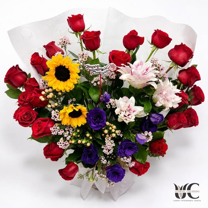 Lush Valentine’s Day bouquet with red roses, sunflowers, purple blooms, and pink-white flowers