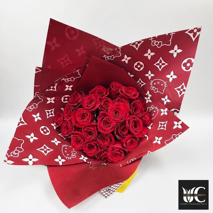 Rounded bouquet of red roses in layered patterned red wrapping
