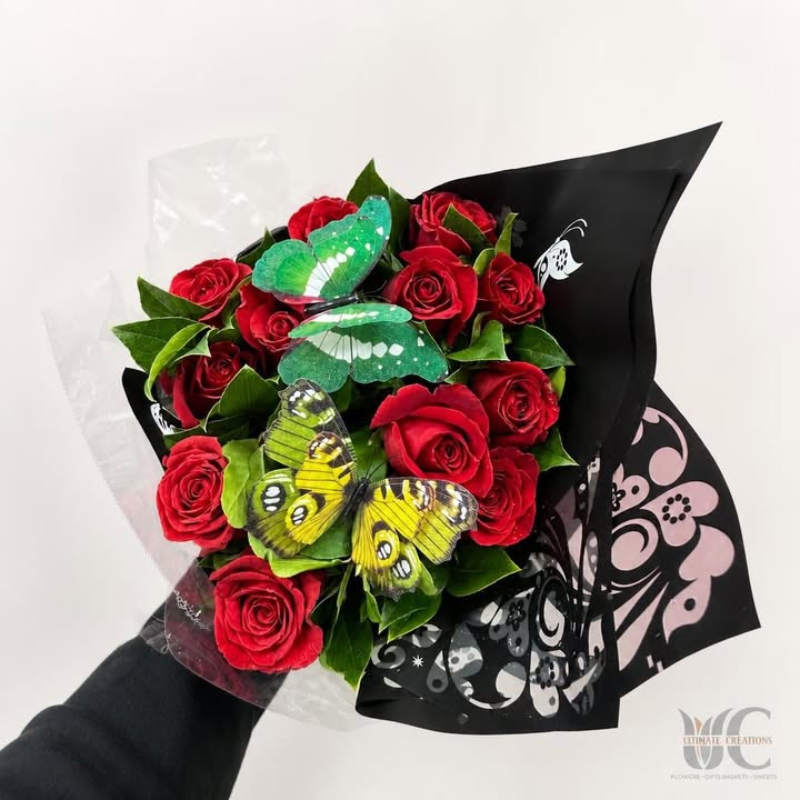 Red rose bouquet with butterflies and patterned black-and-pink wrapping