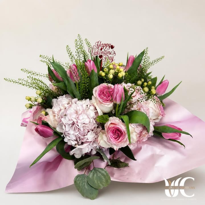 Wrapped pink-and-white bouquet with greenery and yellow accents