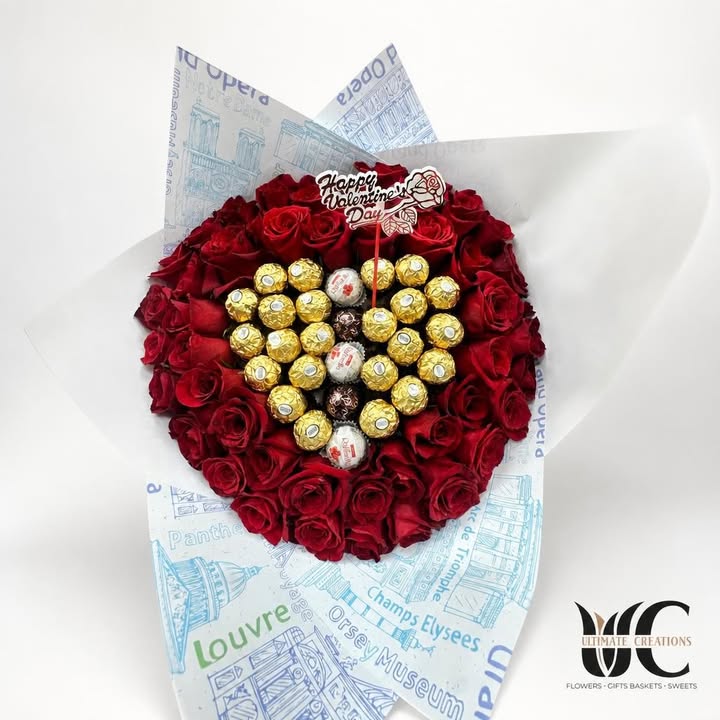 Round bouquet of red roses and wrapped chocolates in illustrated paper with a Valentine’s Day topper.