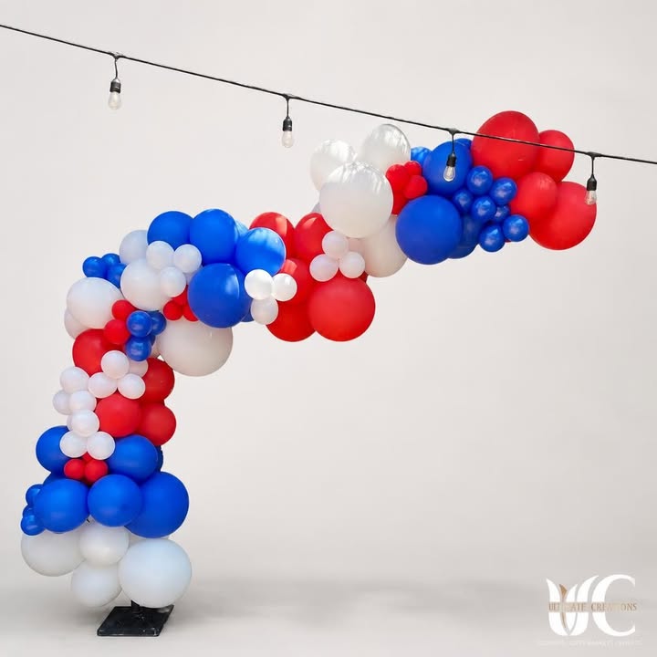 Red, white, and blue balloon arch outdoors