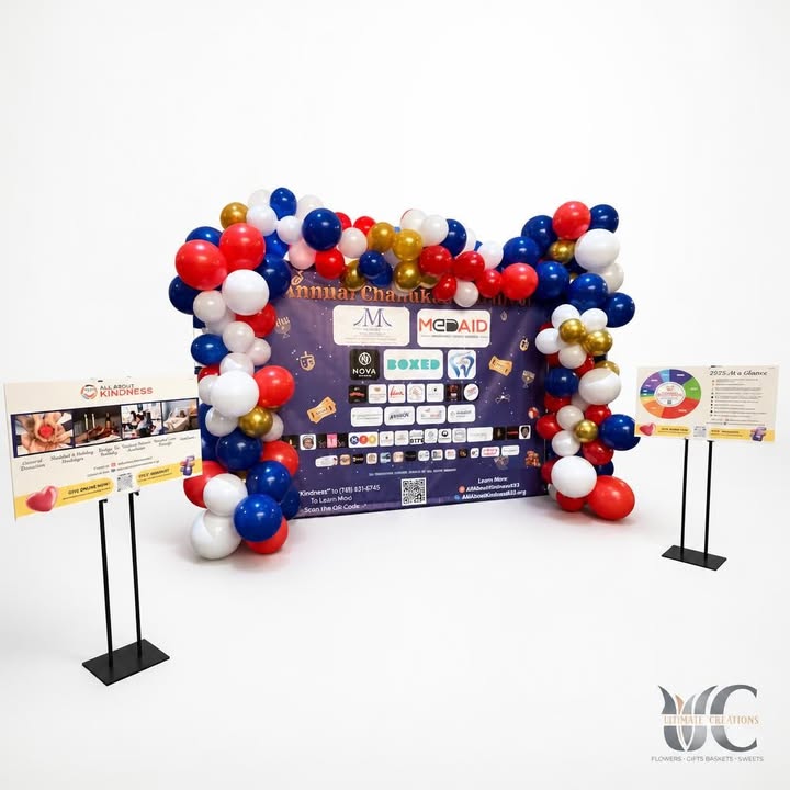 Red, blue, white, and gold balloon garland framing a branded event backdrop