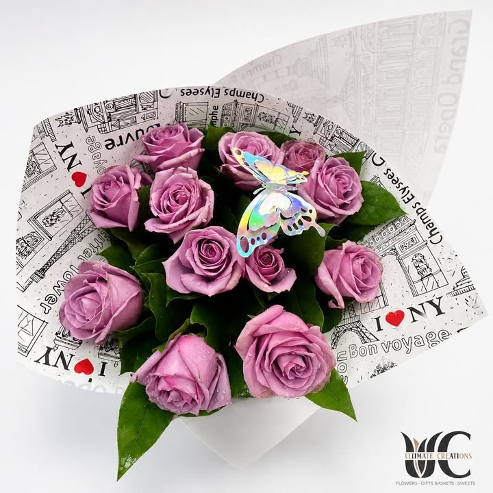 Lavender-pink rose bouquet with greenery, butterfly accent, and graphic wrapping