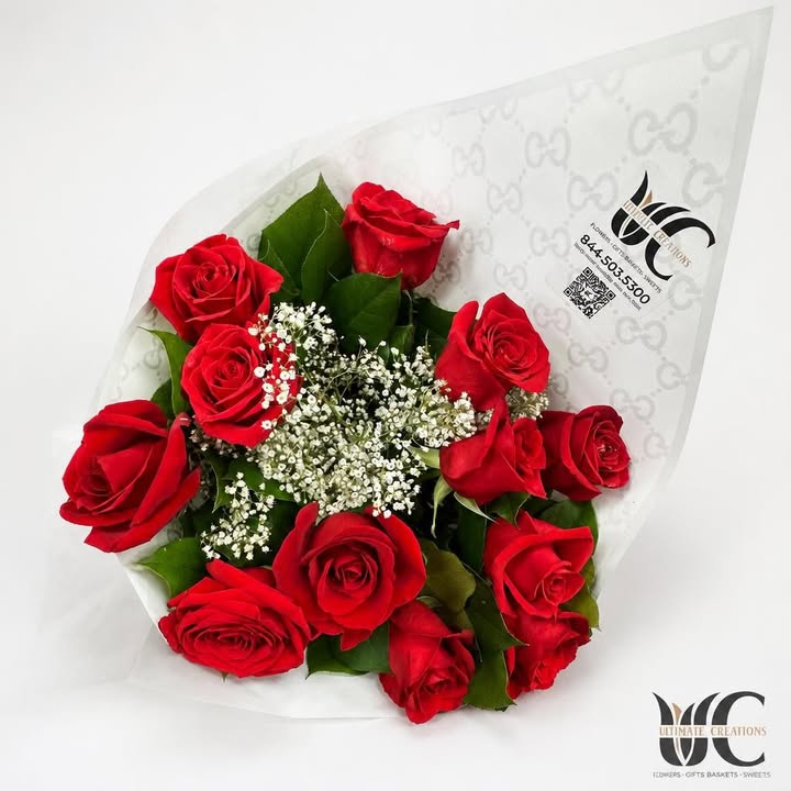 Wrapped bouquet of red roses with white filler flowers and greenery
