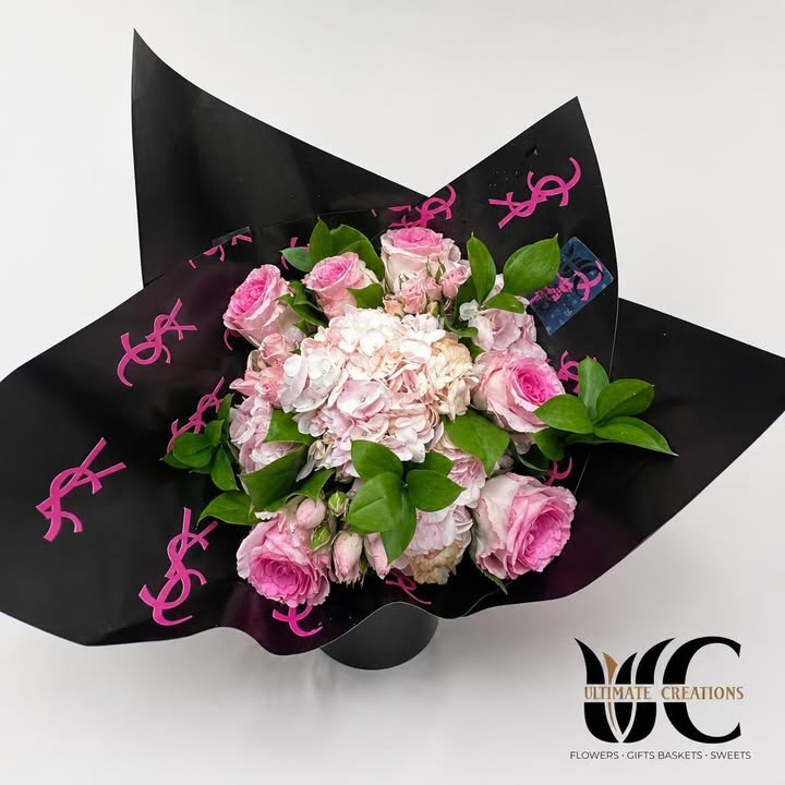 Pink and white flower bouquet with green foliage in black and pink wrapping