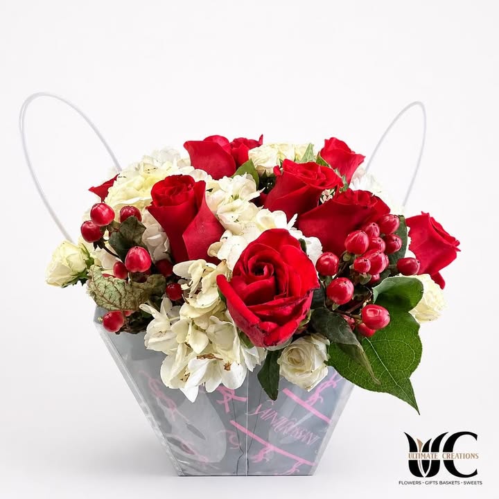 Red and white floral arrangement in a clear handled box