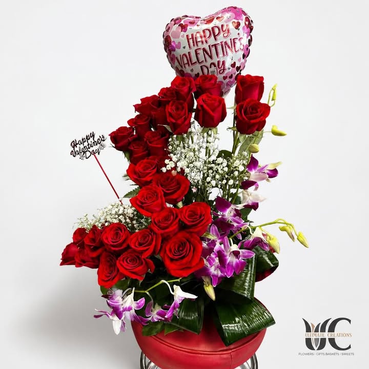 Red rose arrangement with white filler, greenery, and a yellow butterfly accent.