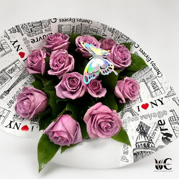 Lavender-pink rose bouquet with green leaves, butterfly accent, and printed wrapping