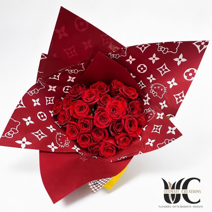 Hand-tied bouquet of red roses in layered red-and-white patterned wrapping