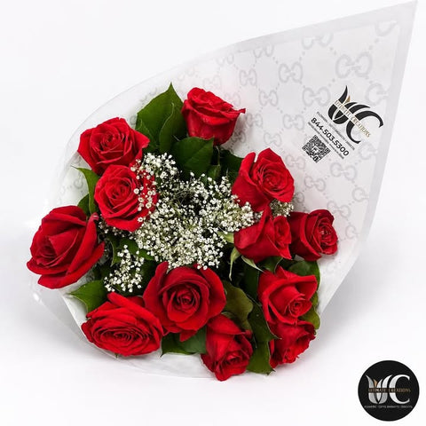 Wrapped bouquet of red roses with white baby’s breath and greenery