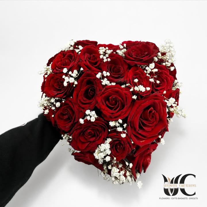 Dense bouquet of red roses with white baby’s breath accents