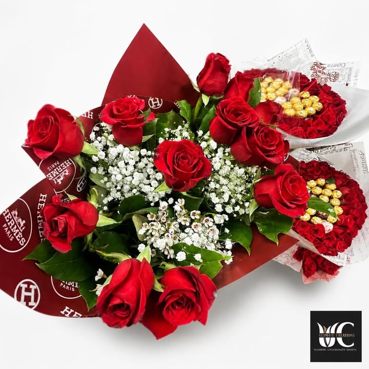Red rose bouquet with white filler flowers, greenery, and red wrapping.