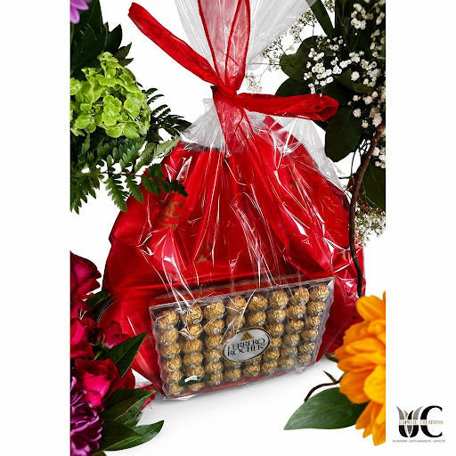 Wrapped floral gift with chocolates, greenery, colorful blooms, and red wrapping.