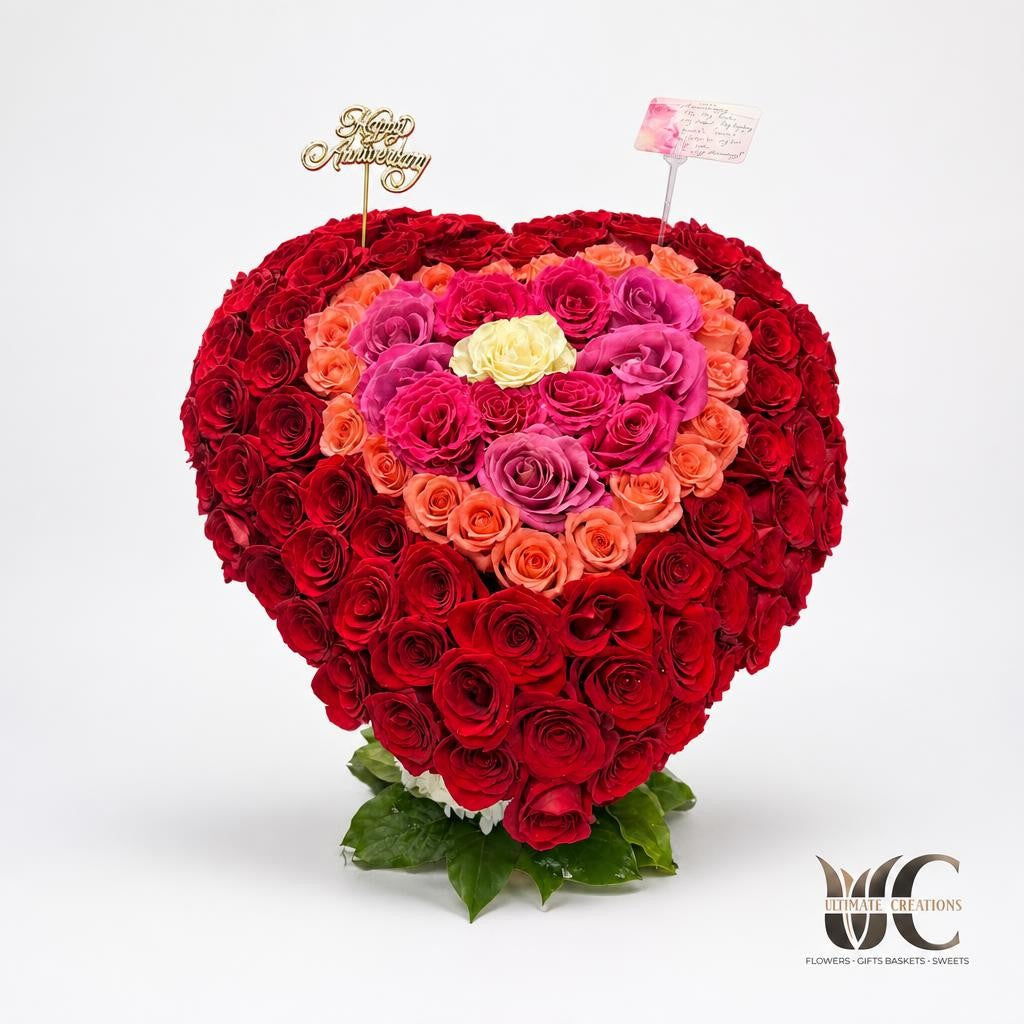 Heart shaped red pink coral and cream rose anniversary arrangement