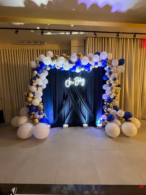 Blue, white and gold baby boy shower balloon backdrop with navy draping and an Oh Baby sign at Kol Israel Jewish Center in Queens, designed by Ultimate Creations NY.