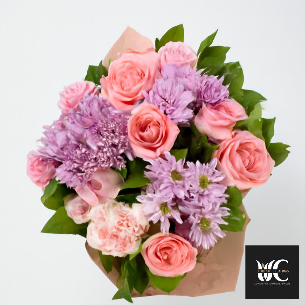 Hand-tied bouquet with pink roses, lavender flowers, and green foliage on a white background.