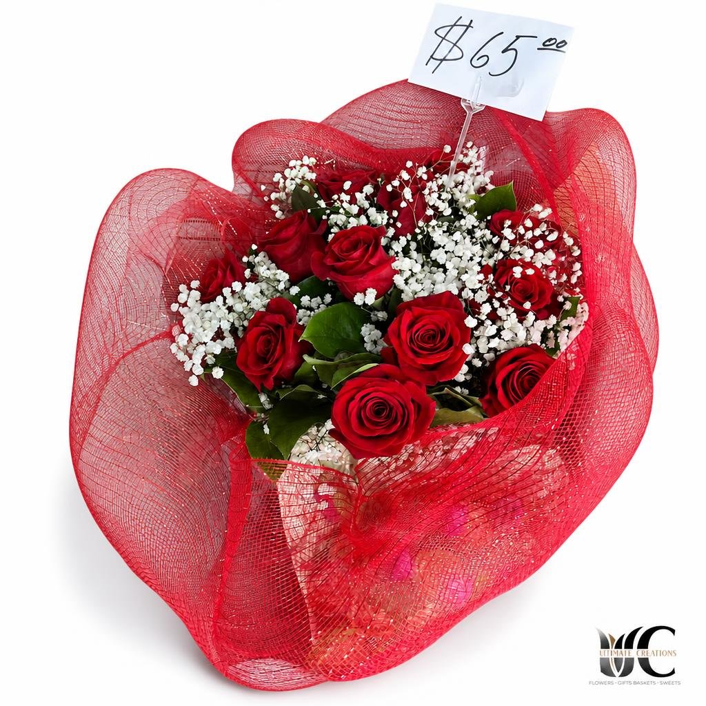 Bouquet of red roses with baby’s breath and green leaves wrapped in red mesh.