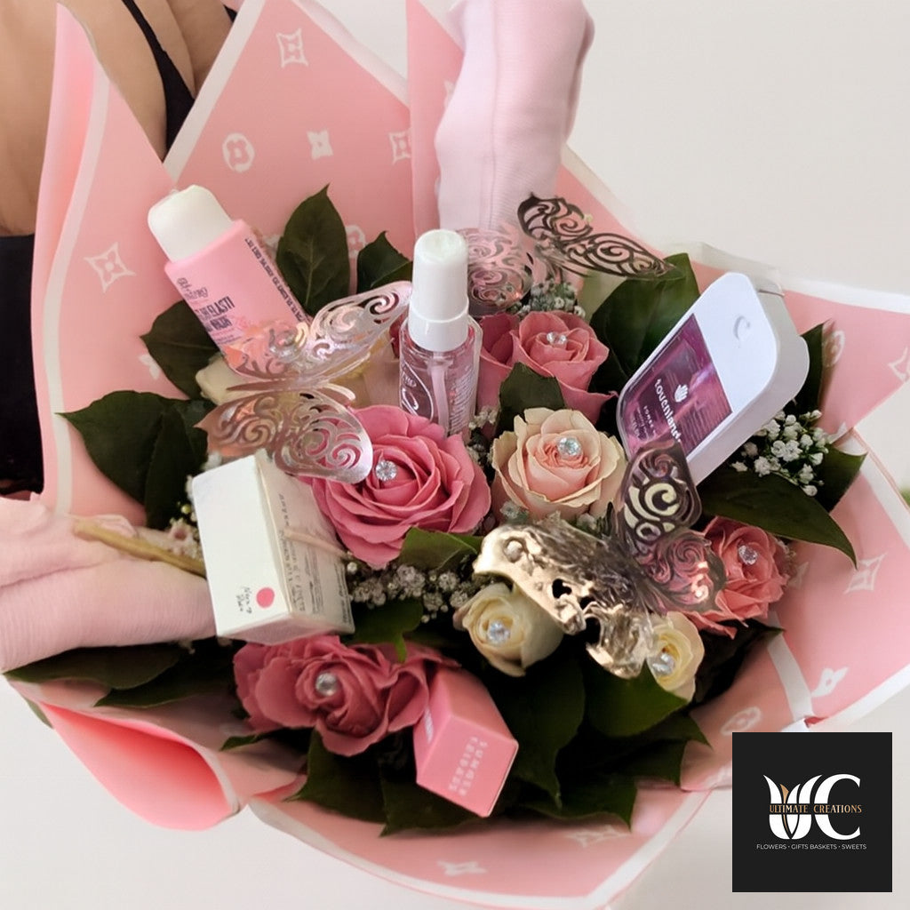 Pink rose bouquet wrapped in blush paper with beauty products and decorative butterfly accents.