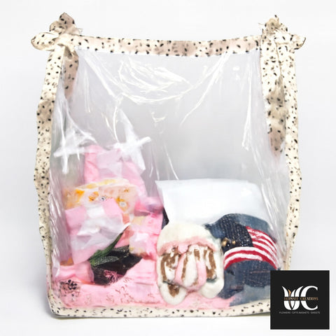 Gift basket wrapped in clear plastic with a patterned ribbon border and assorted items inside.