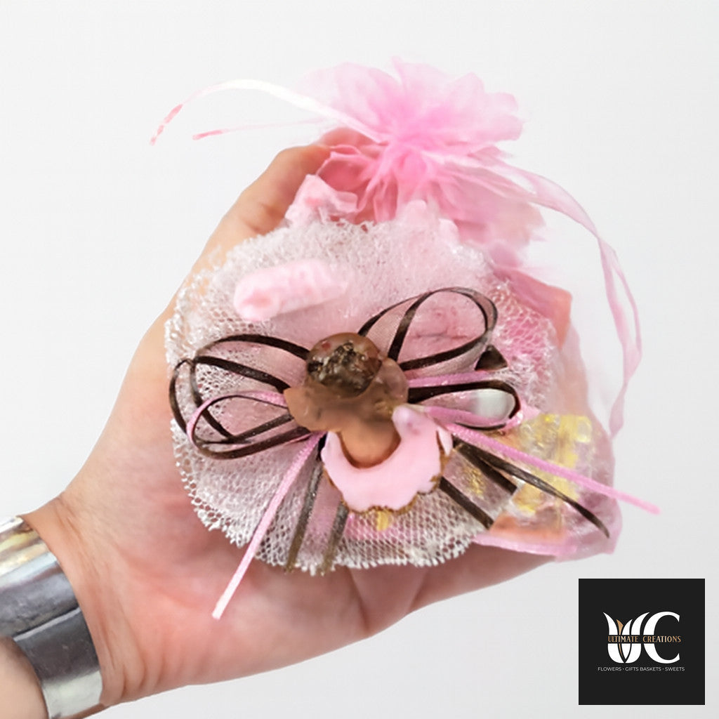 Handheld pink organza favor pouch with ribbon, tulle, and a decorative bow.