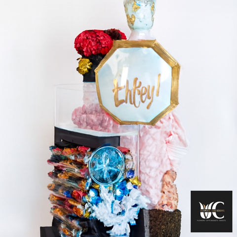 Custom decorative arrangement with bold red, blue, gold, black, and pink accents in a tall display.