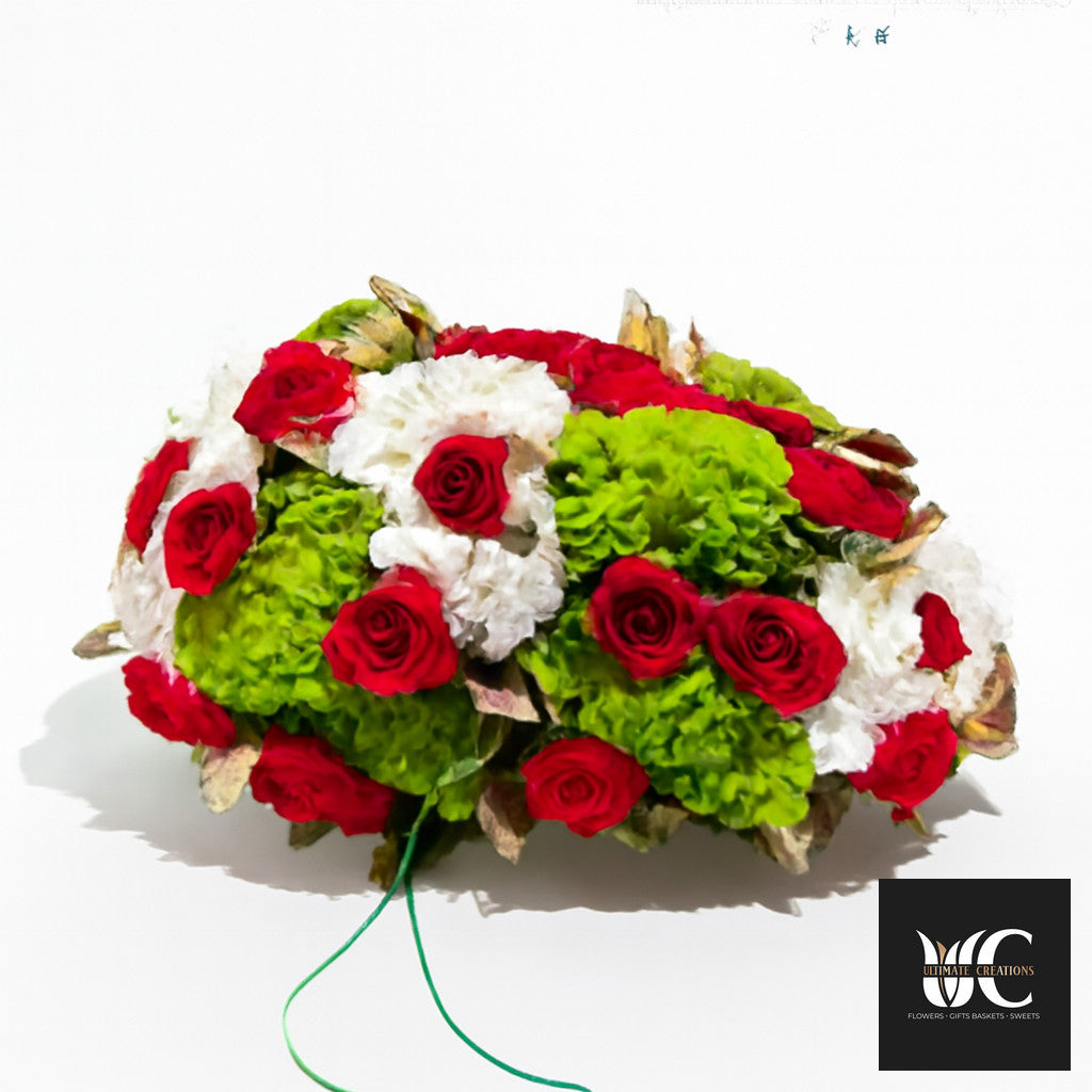 A round bouquet of red roses with green and white flowers arranged on a white background.