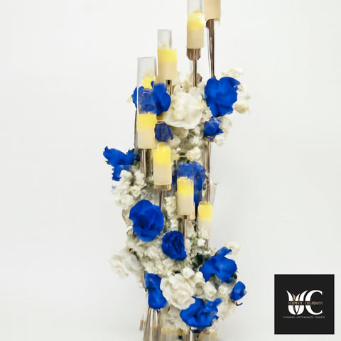 Tall blue and white floral centerpiece with multiple candle stands and a vertical cascading arrangement.