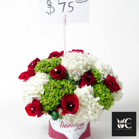 Round floral arrangement with red roses, white flowers, and green textured blooms in a wrapped container.