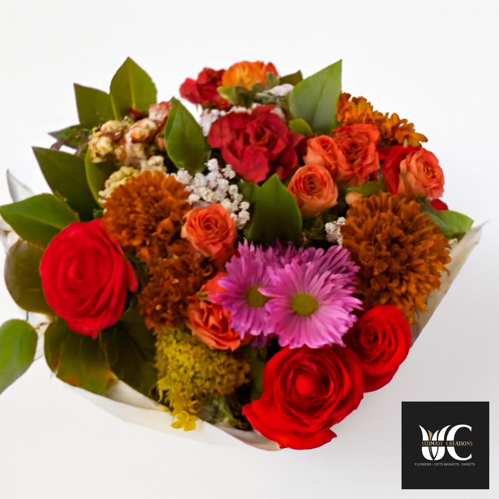 Colorful bouquet of red, orange, pink, and purple flowers with green leaves on a white background.