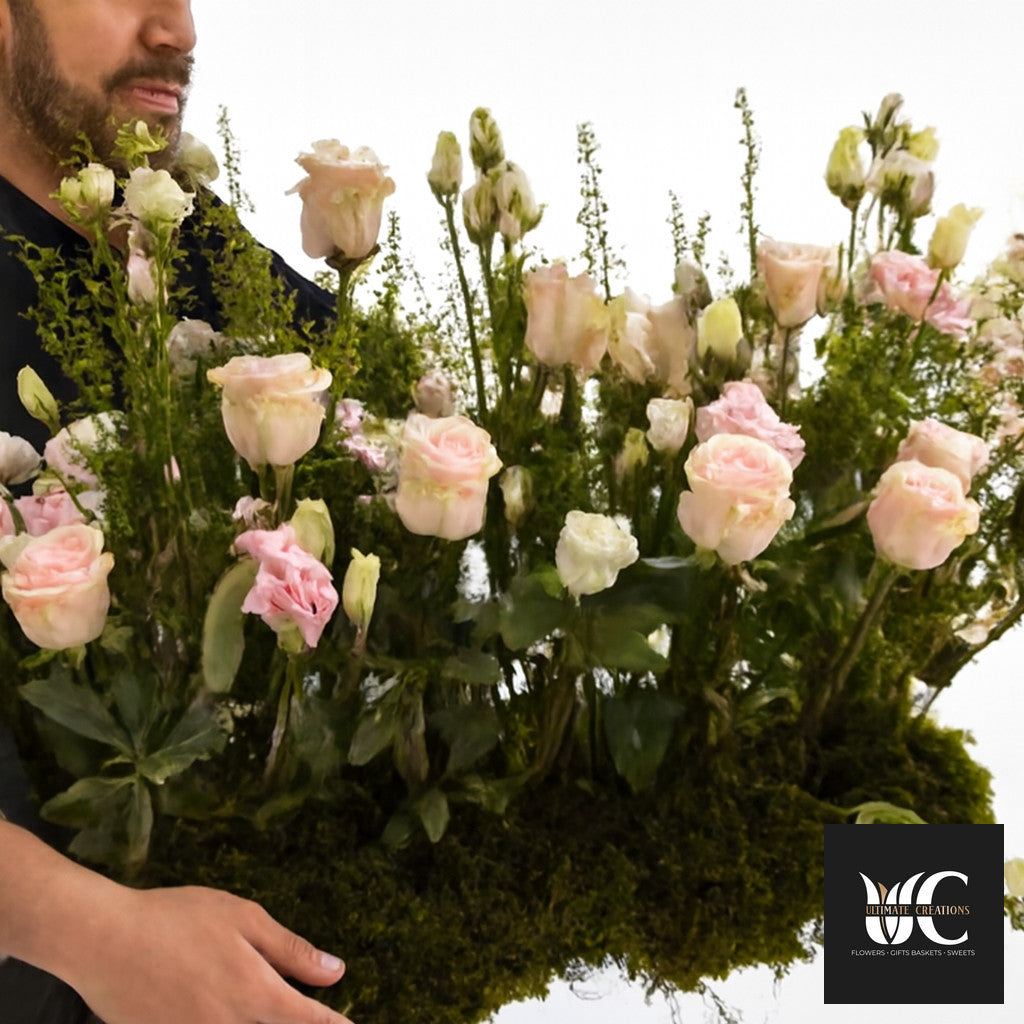 Large garden-style flower arrangement with blush pink roses, cream blooms, and abundant greenery.