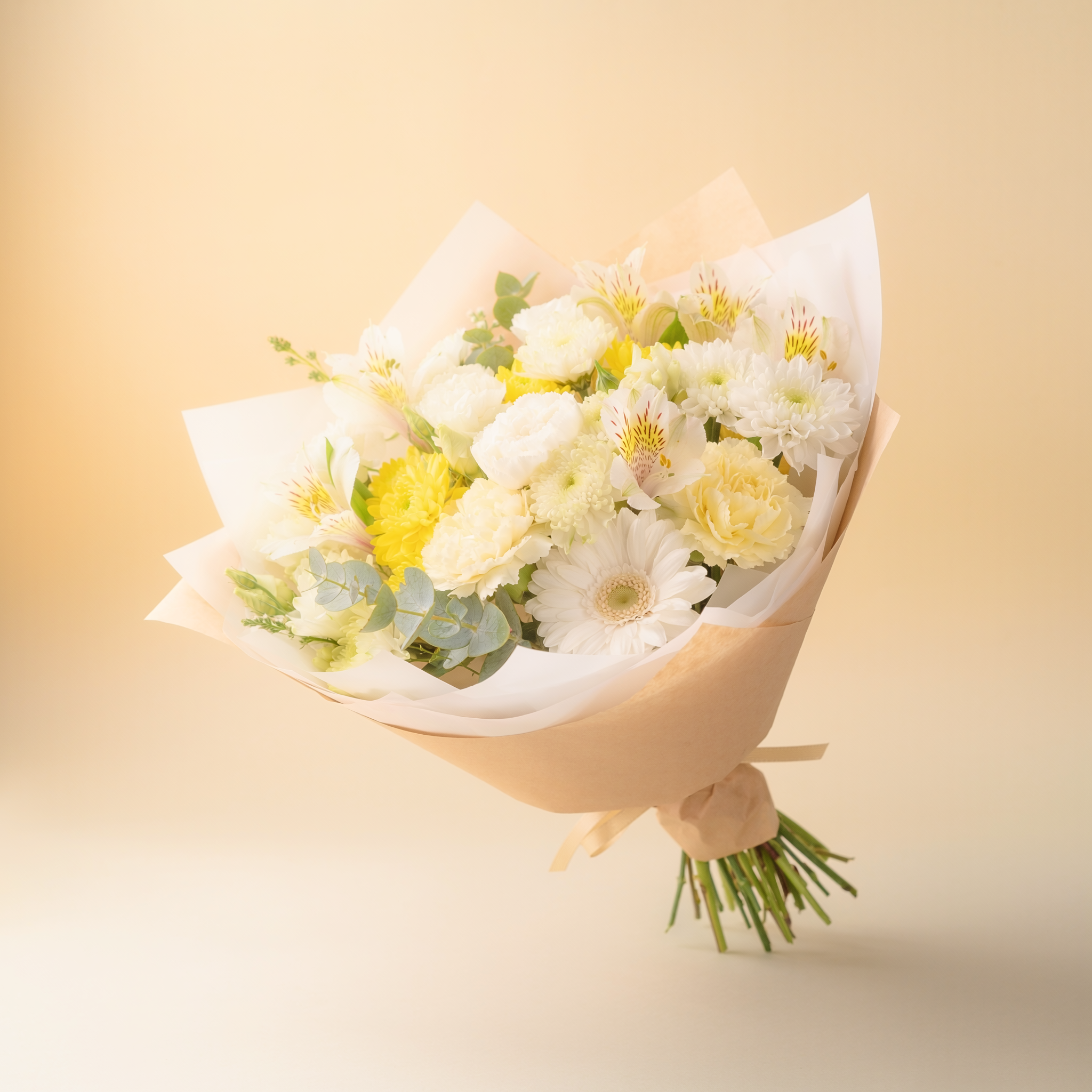 White and yellow seasonal example of a $25 florist's choice hand-tied bouquet