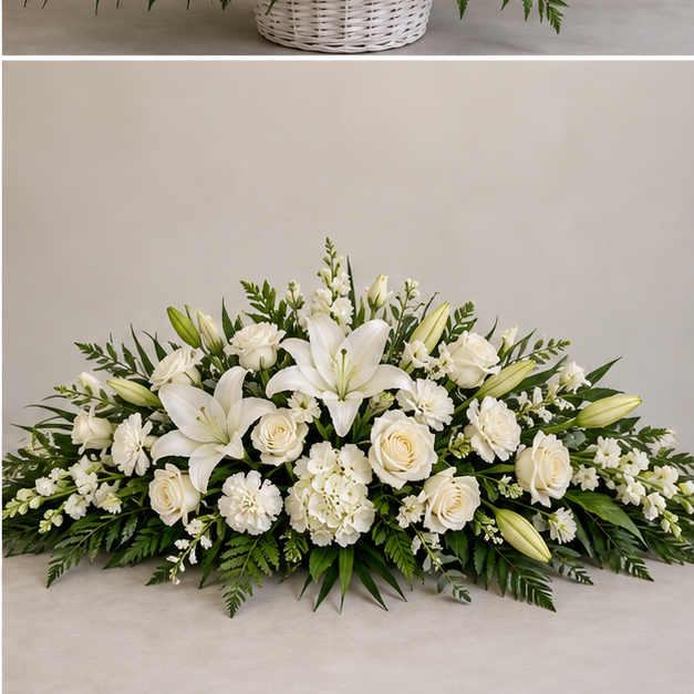 Low white and green graveside memorial spray with lilies roses and greenery