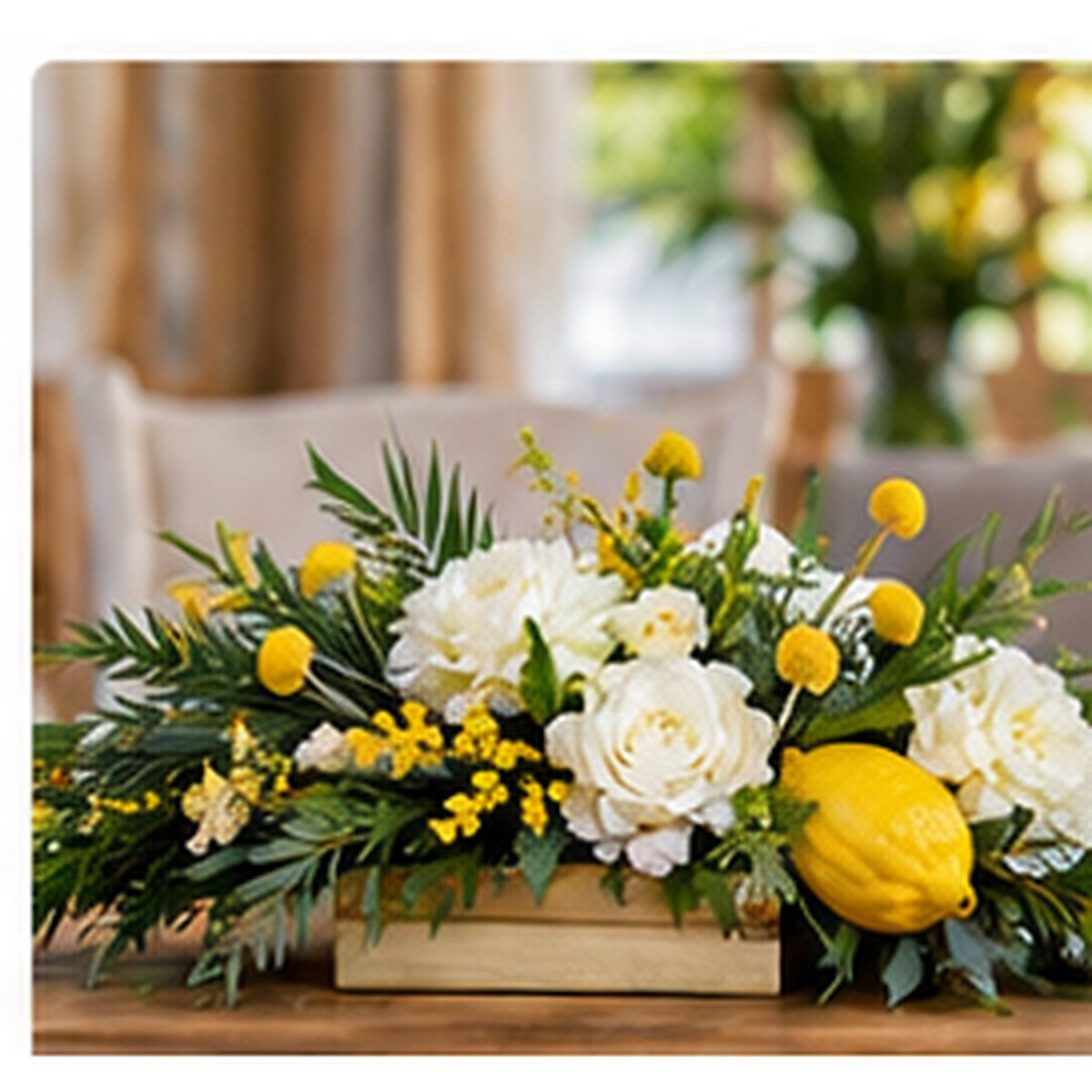 Modern Sukkot table arrangement with white flowers, greenery and yellow accents