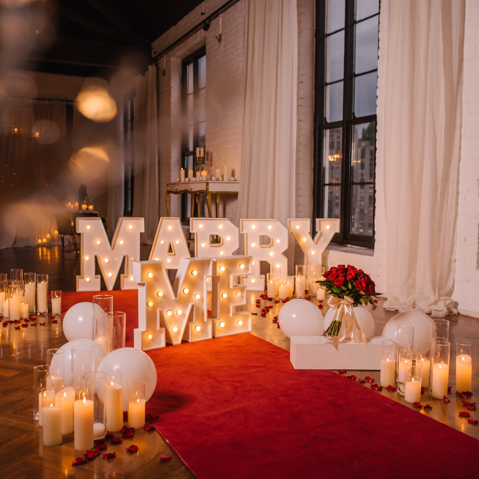 Silver NYC proposal package with red carpet, candles, balloons and MARRY ME letters