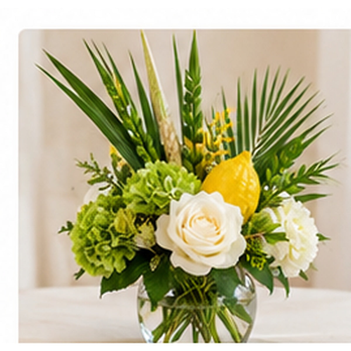 Small Sukkot table arrangement with fresh white flowers, greenery and seasonal yellow accents