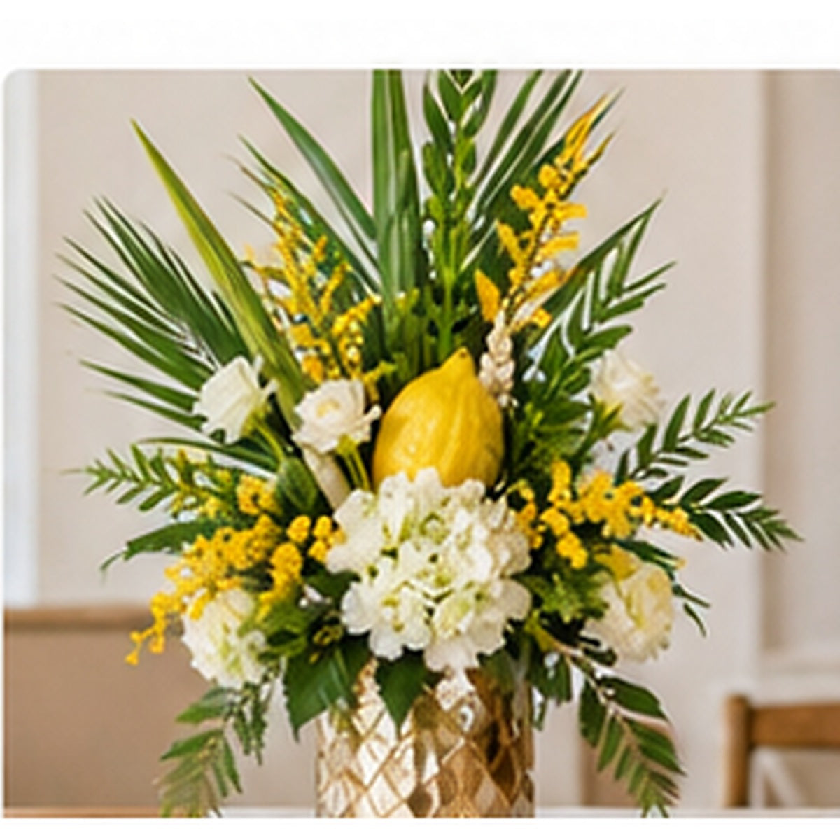 Tall Sukkot statement centerpiece with fresh white flowers, greenery and seasonal yellow accents