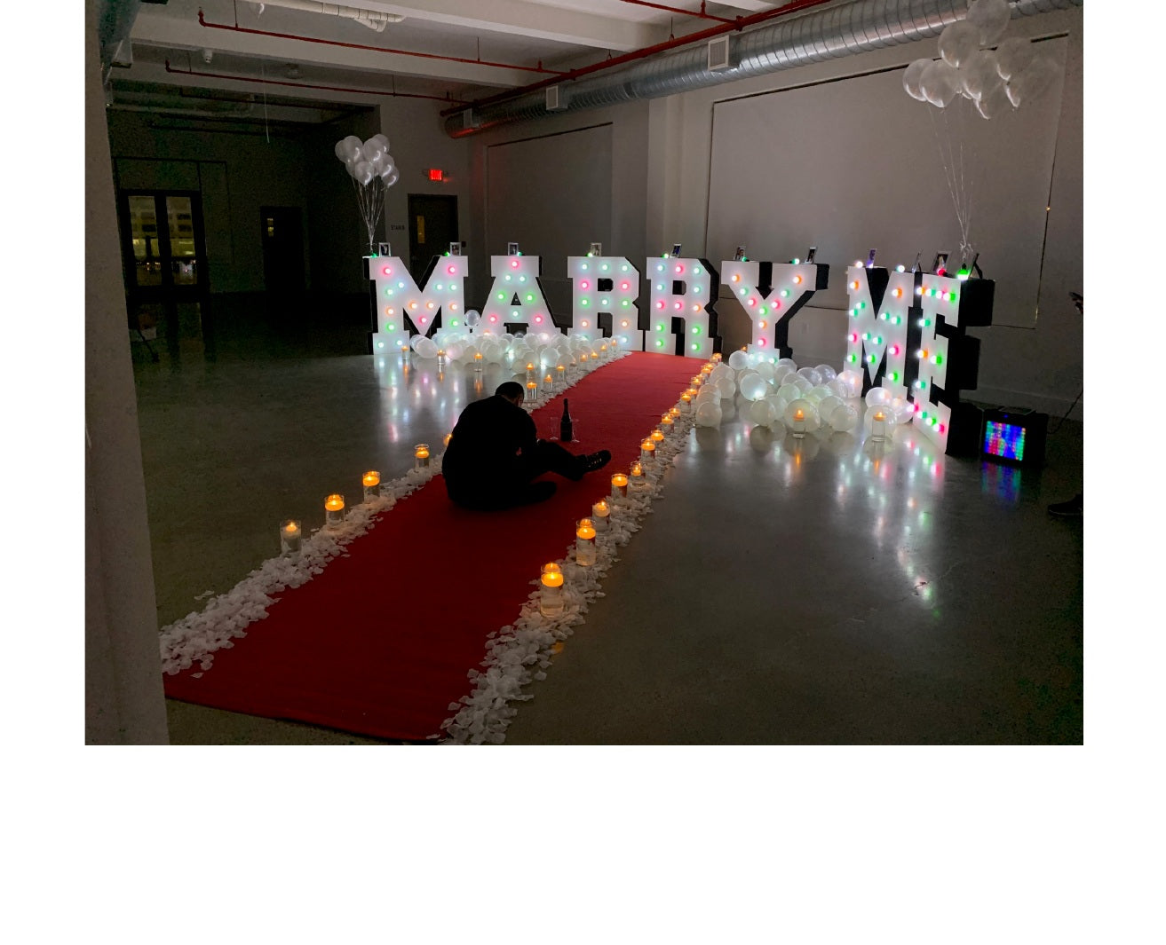 NYC marriage proposal decor with illuminated letters, red carpet and candles